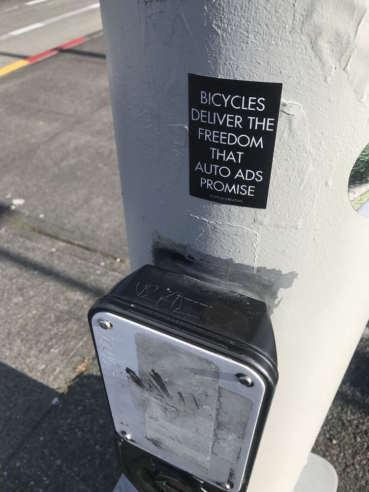 a b/w sticker that says Bicycles deliver the freedom that auto ads promise.